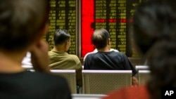 Chinese investors monitor stock prices at a brokerage house in Beijing, Tuesday, Aug. 18, 2015.