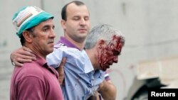 Train driver Francisco Jose Garzon (R) is helped by two men after his train crashed near Santiago de Compostela, northwestern Spain, July 24, 2013. 