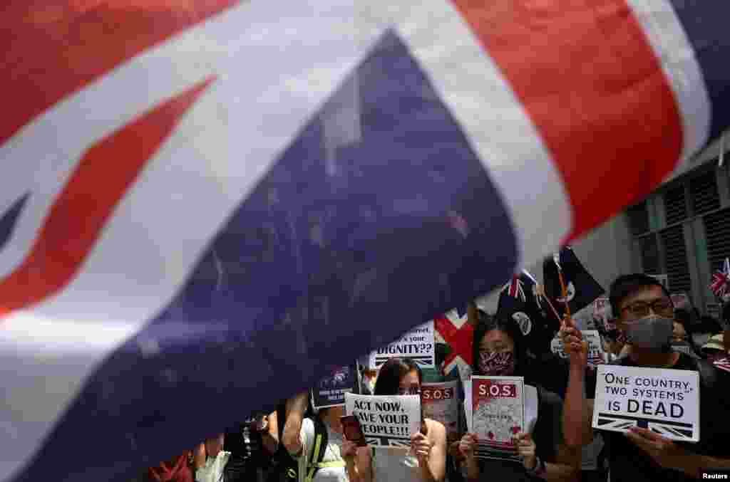 抗议者举着旗帜和标语以及英国国旗在英国驻香港领事馆外集会，呼吁伦敦正视北京破坏《中英联合声明》的问题。(2019年9月15日)