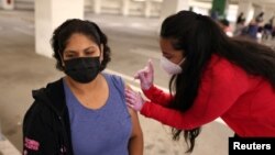 Maria Meza, 43, is given a coronavirus disease (COVID-19) vaccination in Los Angeles, California, U.S., April 12, 2021. 
