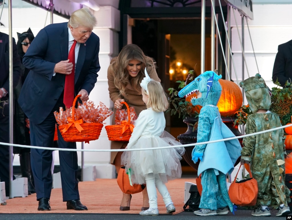 President Donald Trump and first lady Melania Trump hand out treats as they welcome children from the Washington area and children of military families to trick-or-treat celebrating Halloween at the South Lawn of the White House in Washington,Oct. 30, 201