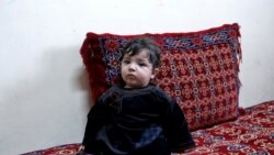 Baby Sohail Ahmadi sits inside the house of Hamid Safi, a taxi driver who found Sohail in the airport, in Kabul, Afghanistan, Jan. 7, 2022.