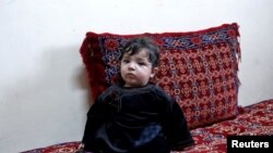Baby Sohail Ahmadi sits inside the house of Hamid Safi, a taxi driver who found Sohail in the airport, in Kabul, Afghanistan, Jan. 7, 2022.