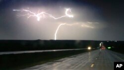Lightning strikes along Interstate 70 near Junction City, Kan., Tuesday, April 26, 2016. Thunderstorms bearing hail as big as grapefruit and winds approaching hurricane strength lashed portions of the Great Plains on Tuesday. (AP Photo/Orlin Wagner)