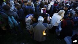 Mourners pray during a candlelight vigil in the aftermath of Monday's Boston Marathon explosions, April 17, 2013, at City Hall in Cambridge, Mass.