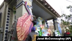 Travis Keene and Joey Mercer are two parade float workers. They are decorating a house in New Orleans, on Friday, Jan. 8, 2021. (AP Photo/Janet McConnaughey)