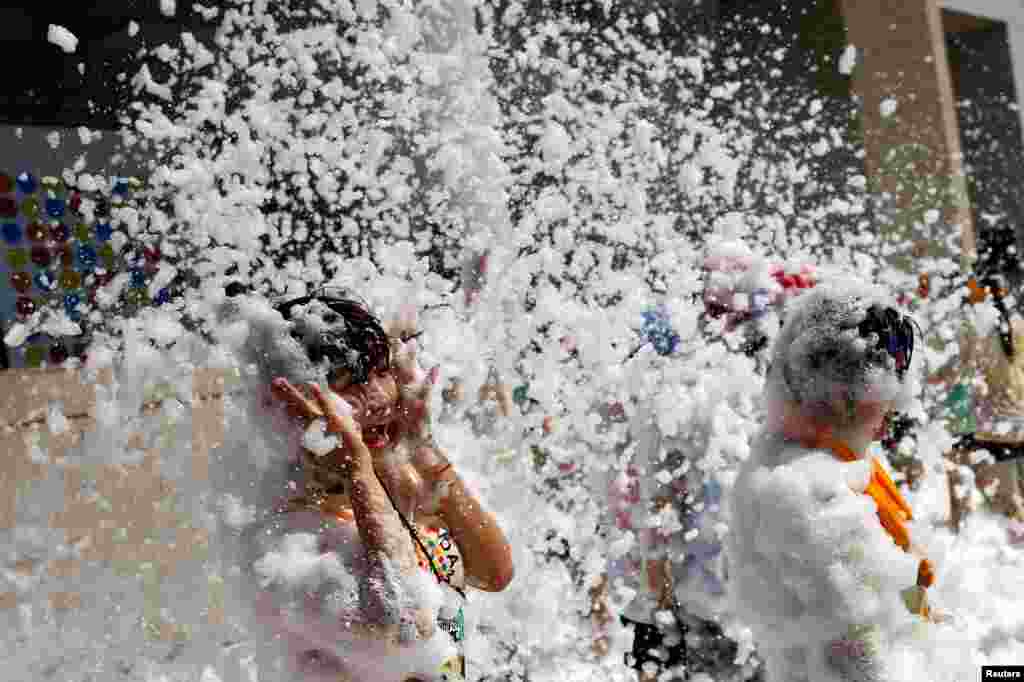 A participant reacts as she runs through foam during the Love Foam Run race in Hsinchu, Taiwan.