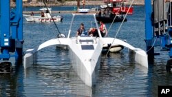 Technicians check the hull and interior of the Mayflower Autonomous Ship at its launch site for it's first outing on water since being built in Turnchapel, Plymouth south west England, Monday, Sept. 14, 2020. (AP Photo/Alastair Grant)