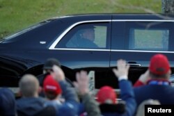 Дональд Трамп приветствует сторонников из президентского лимузина при отъезде с предвыборного митинга в Ньютауне, Пенсильвания