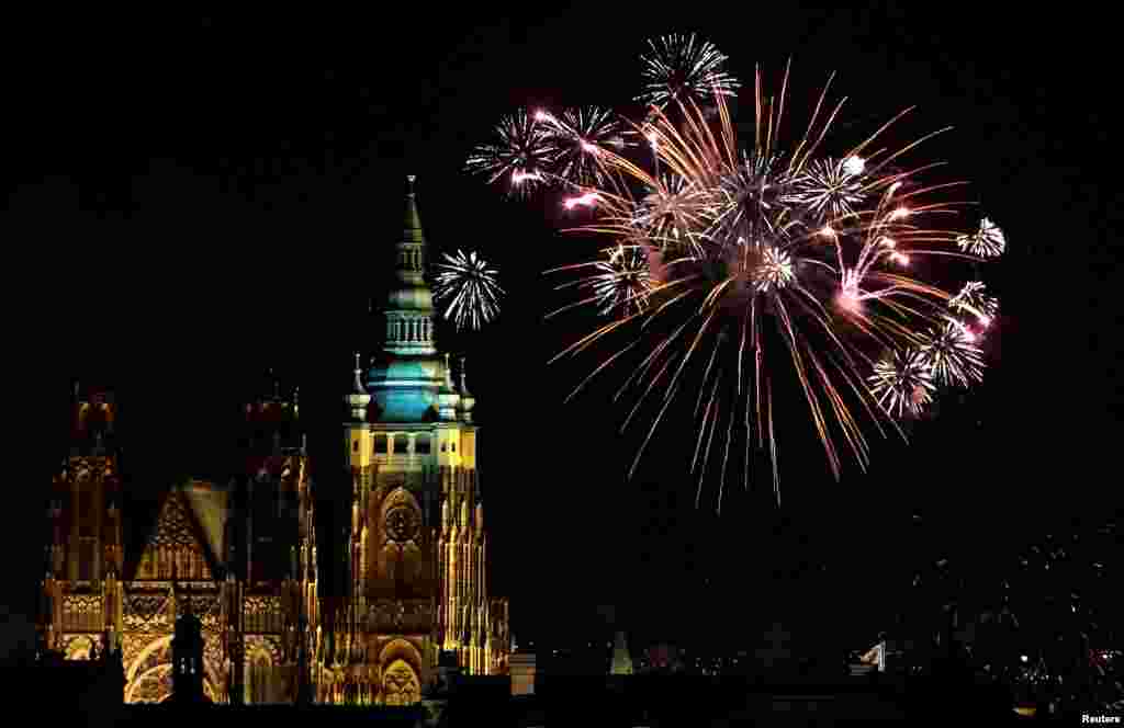 Letupan kembang api menerangi langit di atas menara St. Vitus Cathedral di Kastil Praha, Republik Ceko, menandai hari pertama Tahun Baru, 1 Januari 2018.