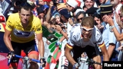 FILE – Lance Armstrong, shown at left in a 2001 Tour de France photo, has been ordered to repay $10 million in bonuses he’d received from a sports promotion company.