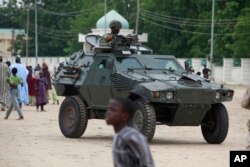 FILE - Nigerian soldiers ride on the armored vehicle in Maiduguri, Nigeria, Aug. 8, 2013. Nigeria is among the few African countries that have increased their military budgets in recent years.