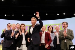 Christian Lindner, front, chairman of the German Liberal Party (FDP), waves as he receives the applause after his speech during a party's convention in Berlin, Sept. 17, 2017,