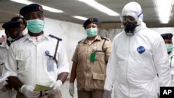 Pejabat kesehatan Nigeria memeriksa penumpang yang mendarat di bandara Lagos, Nigeria untuk mencegah meluasnya wabah ebola di sana, Senin (4/8).