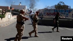Soldiers gesture along a road leading to the Defence Ministry's compound as smoke rises after an attack in Sanaa, Dec. 5, 2013.