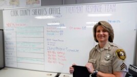 In this Friday, Aug. 13, 2021, photo Sheriff's Police Sgt. Bonnie Busching holds a personal electronic device at the Cook County Sheriff's Office in Chicago. She found the devices to be successful when it calmed down a man who was threatening harm with a knife after he began talking with a mental health expert on the other end. (AP Photo/Nam Y. Huh)