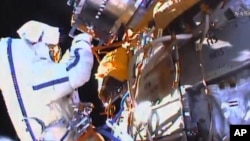 This photo taken from video provided by NASA shows Russian cosmonauts Yuri Malenchenko and Sergey Volkov install fresh experiments outside the International Space Station on Feb. 3, 2016.