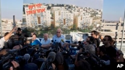 Israeli Minister of Housing and Construction Uri Ariel, center, speaks to journalists during ceremony marking resumption of construction in east Jerusalem, Aug. 11, 2013.