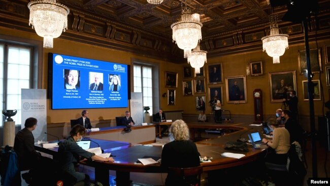 David Haviland, member of the Nobel Committee for Physics, Goran K. Hansson, Secretary General of the Royal Swedish Academy of Sciences and Ulf Danielsson, member of the Royal Swedish Academy of Sciences, announce the winners of the 2020 Nobel Prize in Physics, seen on screen.