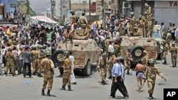 Yemeni army soldiers block the way as anti-government protesters attend a demonstration demanding the resignation of Yemeni President Ali Abdullah Saleh, in Taiz, Yemen, April 7, 2011