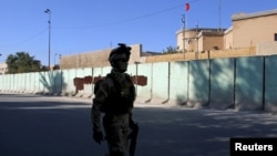 A member from Iraqi security forces walks past the Turkish embassy in Baghdad, Dec. 8, 2015.