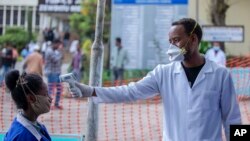 Des Ethiopiens font vérifier leur température pour détecter les symptômes du nouveau coronavirus, au Zewditu Memorial Hospital dans la capitale Addis Abeba, Ethiopie, mercredi 18 mars 2020. (AP Photo/Mulugeta Ayene)