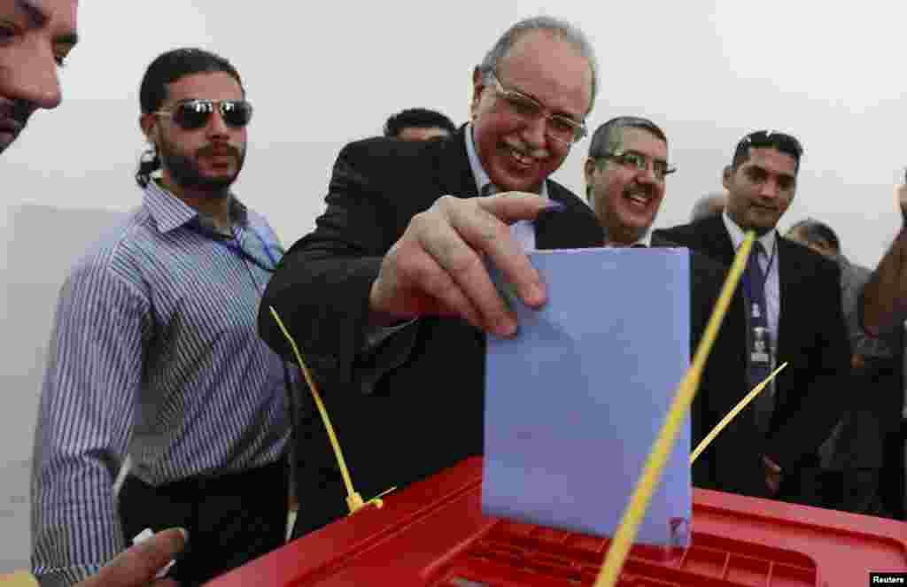 Libya's Prime Minister Abdurrahim El-Keib casts his ballot during the National Assembly election at a polling station in Tripoli July 7, 2012. Libyans, some with tears of joy in their eyes, queued to vote in their first free national election in 60 years 