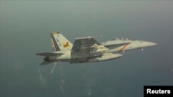 Pesawat tempur Amerika F/A-18F Super Hornet tampak di langit Teluk Arab. Gempuran pesawat tempur AS berhasil memperlambat operasi kelompok ISIS namun tidak tuntas melemahkan ISIS, demikian dikatakan Pentagon (10/8/2014). 