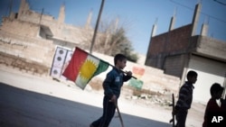 (자료사진) 시리아 북서부지역 거주 쿠르드족 소년들이 총과 국기를 들고 걸어가고 있는 모습