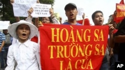 Demonstran Vietnam memegang spanduk bertuliskan "Kepulauan Paracel dan Spratly milik Vietnam dalam protes menuntut Tiongkok agar menjauh dari wilayah yang diklaim milik Vietnam (foto: Dok).