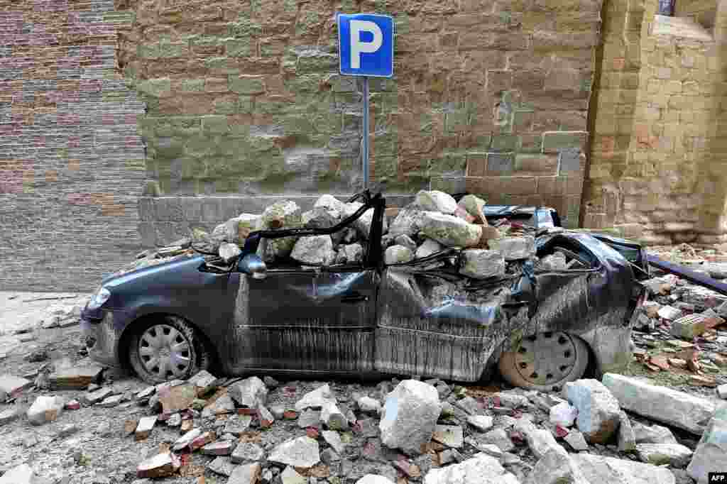 A damaged car in the &quot;red zone&quot;, an area cordoned off for safety reasons, in Camerino, where 80 per cent of the houses have been left uninhabitable after two earthquakes hit the region.&nbsp;
