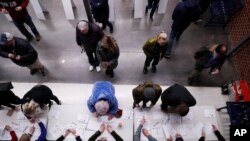 Caucus goers check in at a caucus at Roosevelt High School, in Des Moines, Iowa, Feb. 3, 2020. 