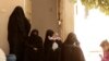 FILE - Women who recently returned from the Al-Hol camp, which holds families of Islamic State members, gather in the courtyard of their home in Raqqa, Syria, during an interview, Sept. 7, 2019.