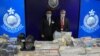 Senior Superintendent Li Kwai-wah, left, of Hong Kong Police National Security Department, and senior bomb disposal officer Alick McWhirter, right of Explosive Ordnance Disposal Bureau, pose with the confiscated evidence during a news conference.