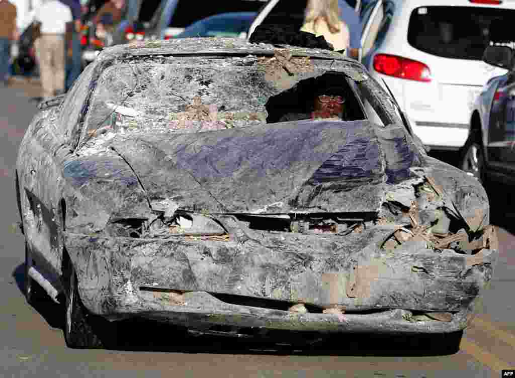 A resident drives his damaged car after a tornado hits Tuscaloosa, Alabama, on Thursday, April 28. (AP Photo/Butch Dill)