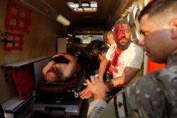 Un soldado libanés revisa a un herido dentro de una ambulancia en el lugar de una explosión en el puerto de Beirut, Líbano, el 4 de agosto de 2020.