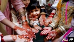 Anak-anak perempuan di Peshawar, Pakistan menghiadi tangan mereka dengan hiasan "henna" untuk menyambut Idul Fitri.