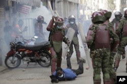 Kenya ant-riot police beat a protester in downtown Nairobi, Kenya, Tuesday, July 2, 2024. (AP Photo/Henry Naminde)