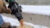In a demonstration, a bucket is filled with beet juice at the Pennsylvania Department of Transportation's Butler, Pa., maintenance facility, Jan. 6, 2014, which is then mixed with road rock salt that is largely ineffective below 16 degrees.