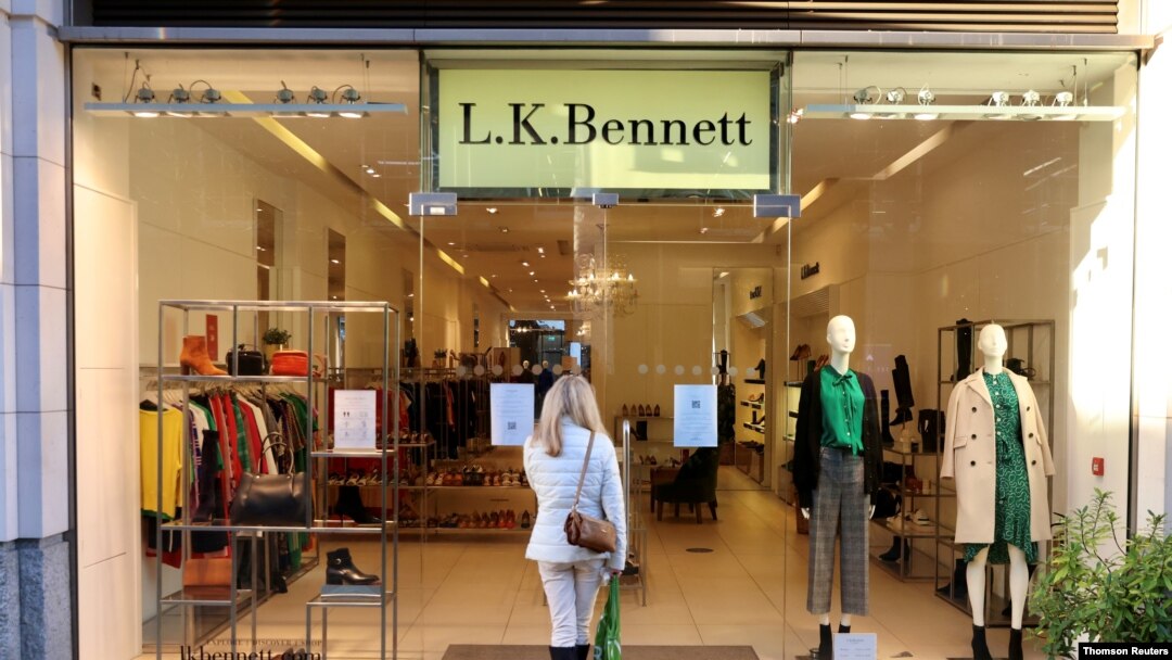 Una mujer mira una tienda cerrada en Kings Road, en Chelsea, Londres, mientras el gobierno británico impone un conjunto de restricciones escalonadas más estrictas en medio de la pandemia de COVID-19, el 20 de diciembre de 2020.