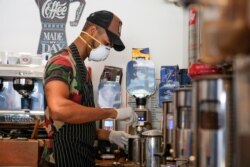 A worker wears a protective face mask as he prepares coffee at a cafe following the outbreak of the coronavirus disease (COVID-19), in Benghazi, Libya August 9, 2020. Picture taken August 9, 2020. REUTERS/Esam Omran Al-Fetori