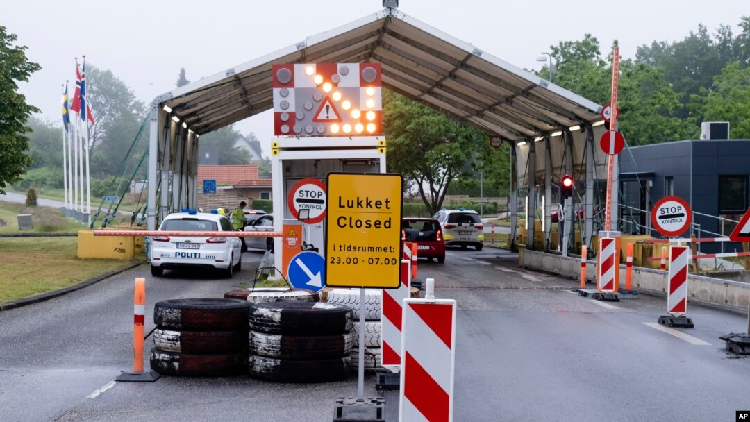 A sign with the opening hours of the border checkpoint between Harrislee in Germany and Padborg in Denmark is displayed in front the border crossing in Harrislee, Germany, June 13, 2020.