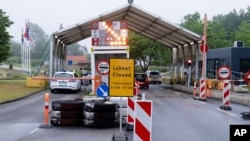 A sign with the opening hours of the border checkpoint between Harrislee in Germany and Padborg in Denmark is displayed in front the border crossing in Harrislee, Germany, June 13, 2020.