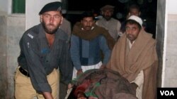 Polisi dan warga membawa seorang anggota polisi yang terluka akibat serangan Taliban di Daraban, dekat Dera Ismail Khan, Pakistan (23/11).