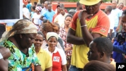 Voters produce identity documents as they go through the voting process at a polling station, in Maputo, Mozambique, Oct. 15, 2014.