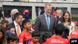 El rey español Felipe VI y el presidente ecuatoriano Daniel Noboa saludan a niños durante la inauguración de una cancha de fútbol en Cuenca, en el marco de la Cumbre Iberoamericana XXIX Ibero-American Summit, el 14 de noviembre de 2024. (AP/Fernando Machado)