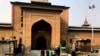 Turis India berfoto di luar Masjid Jamia yang terkunci, atau masjid agung di Srinagar, Kashmir yang dikuasai India, 13 November 2021. (Foto: AP/Mukhtar Khan)