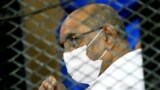 FILE - Sudan's ousted President Omar al-Bashir is seen inside the defendant's cage during his and some of his former allies' trial over the 1989 military coup that brought him to power in 1989, at a courthouse in Khartoum, Sudan, Sept. 15, 2020.