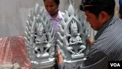 One of the four new statues is positioned by a worker from the World Monuments Fund. (VOA/ L. Hunt)