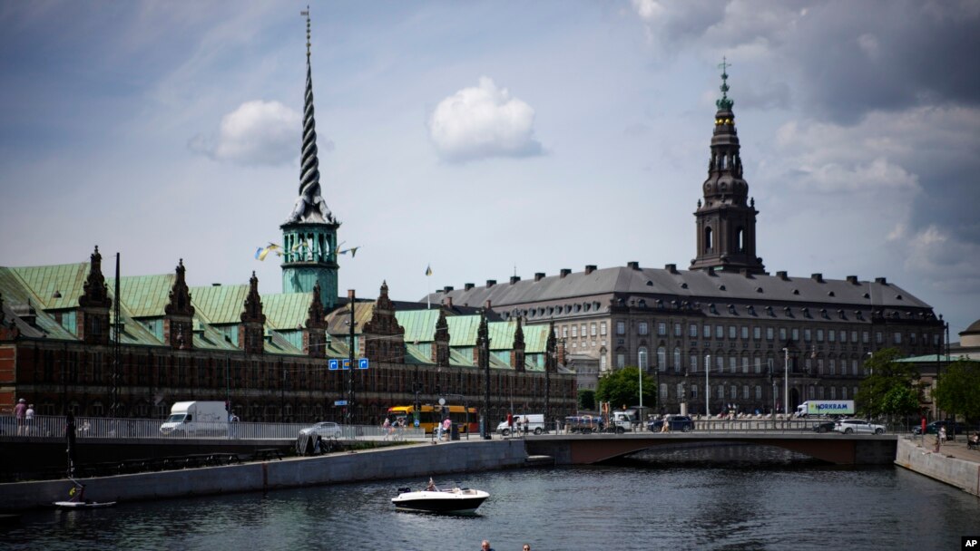 ARCHIVO - Un barco navega por el río Nyhavn, con el edificio de la Antigua Bolsa de Valores al fondo, en Copenhague, Dinamarca, el 29 de junio de 2022.